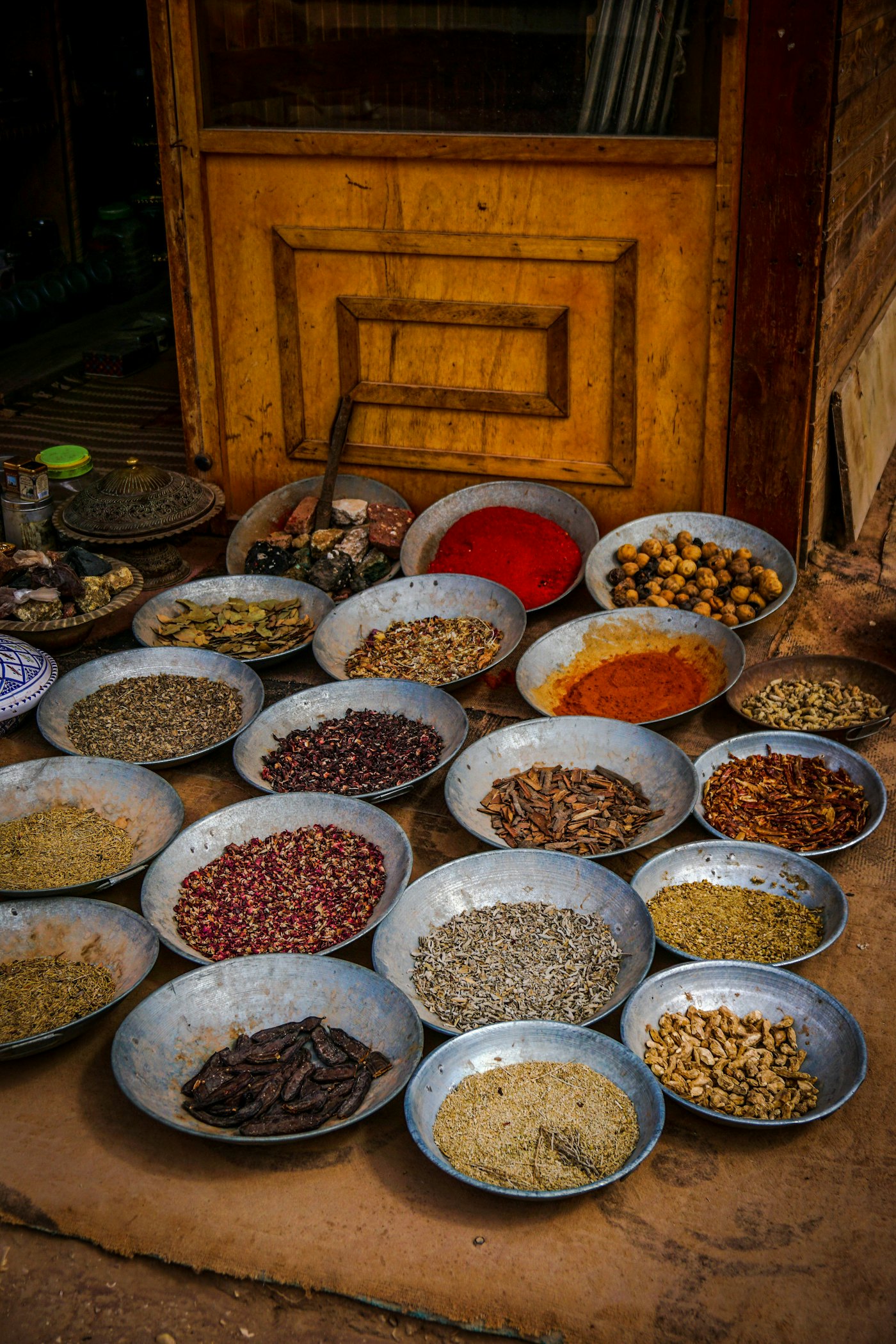 Rows of metal bowls holding whole and ground spices